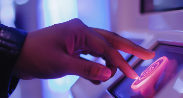 Finger touching a glowing fingerprint sensor on a security device